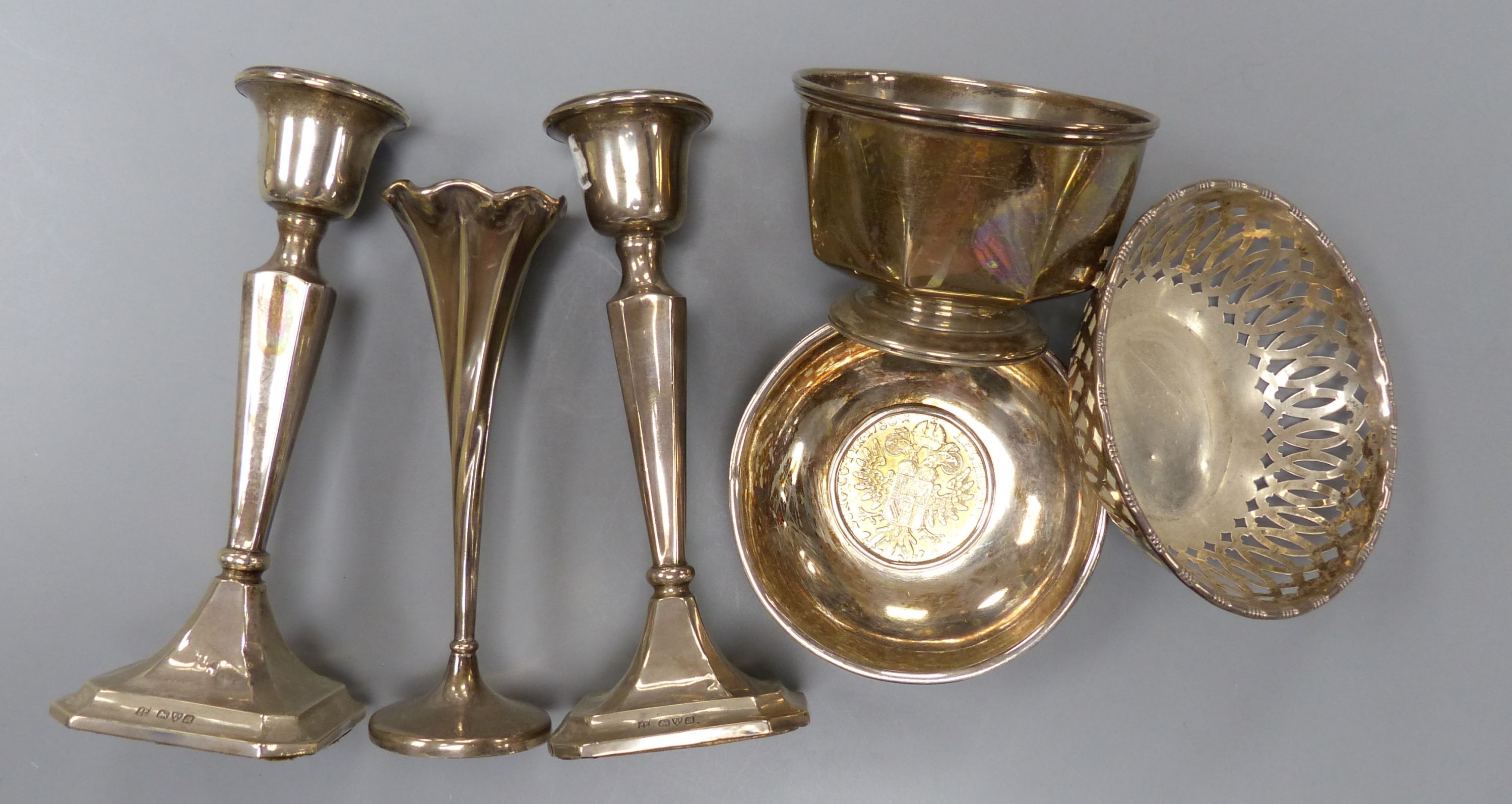 A pair of George V silver mounted candlesticks, 15.2cm, a silver posy vase, silver bowl, silver pierced dish and a 925 inset coin dish.